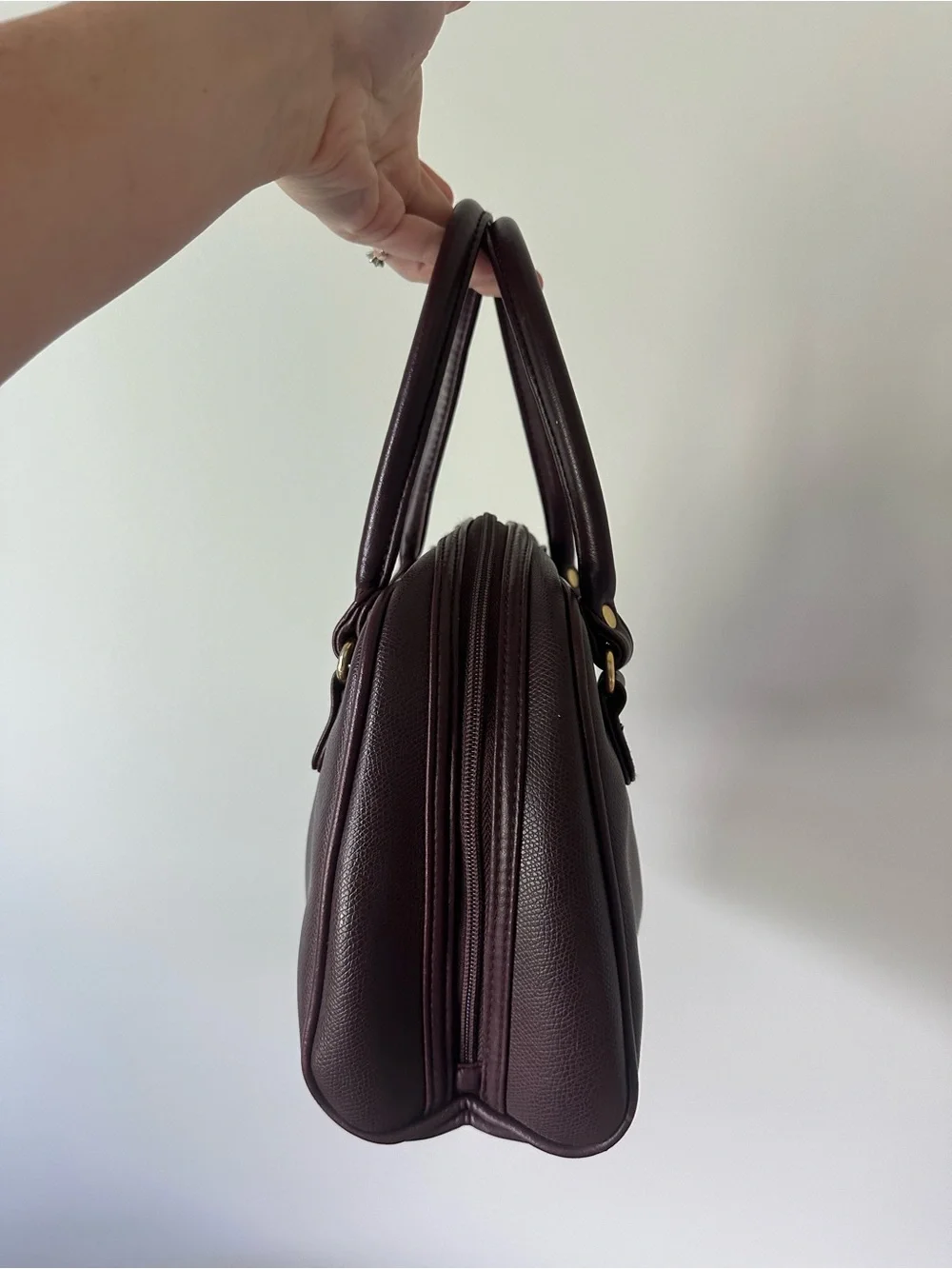 Vintage-inspired burgundy/oxblood structured handbag with gold accents